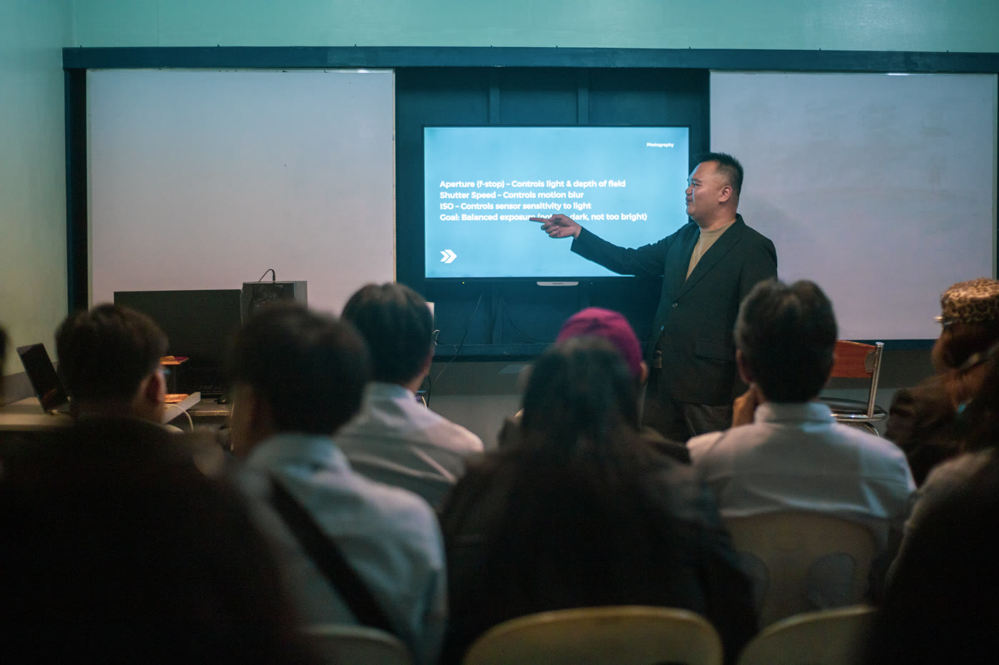 A guest speaker presenting to multimedia arts students in a seminar room